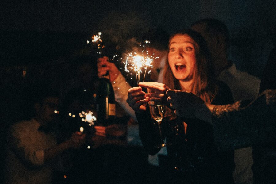 Woman celebrating with sparklers making new year's resolutions