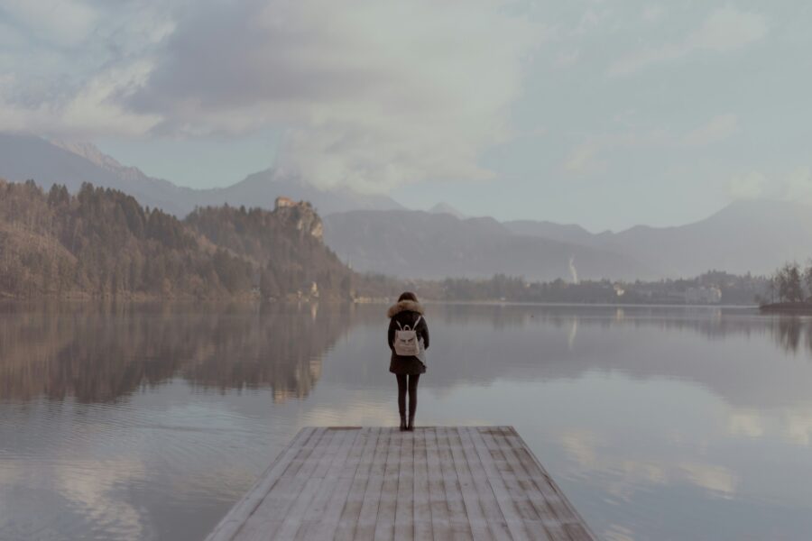 Girl on dock overlooking lake while struggling with self sabotaging behavior