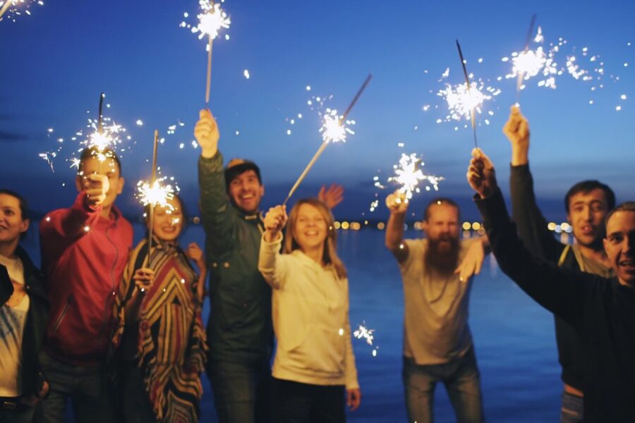 People celebrating milestones in recovery with sparklers at night