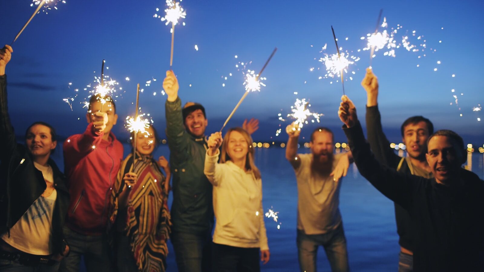 People celebrating milestones in recovery with sparklers at night