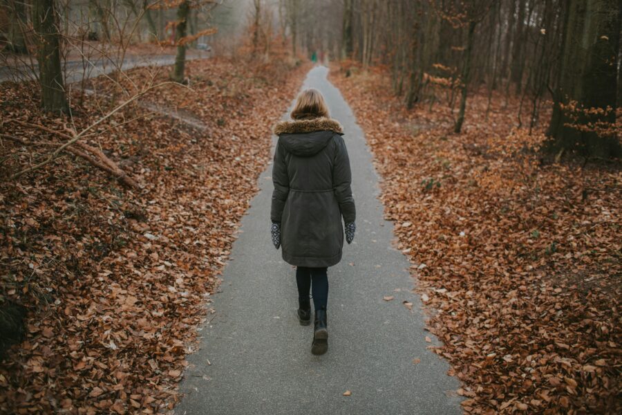 Woman walking on sidewalk practicing mindfulness in recovery