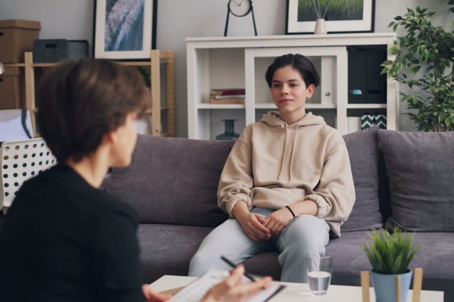 a woman in an intensive outpatient program sitting on a couch talking to another woman