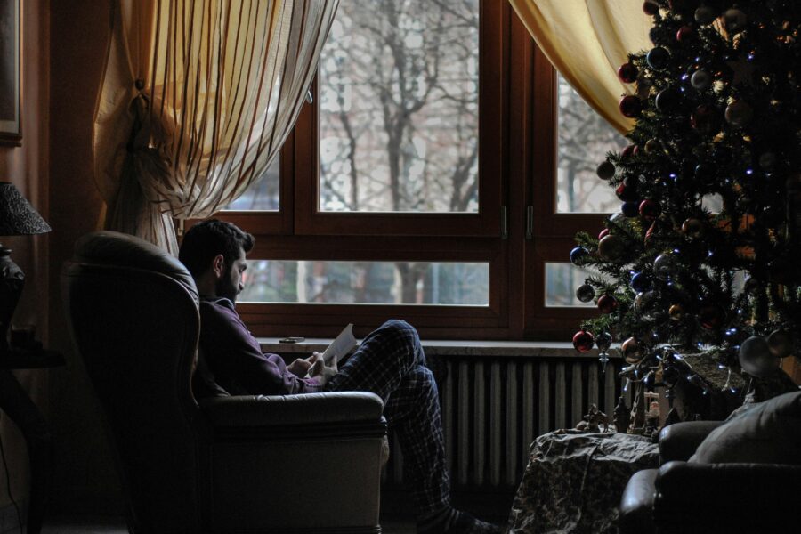 Man struggling with holiday depression by Christmas tree