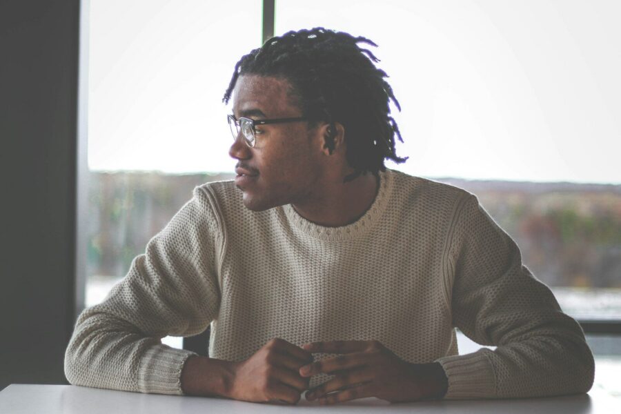 man with medication assisted treatment in white sweater around table