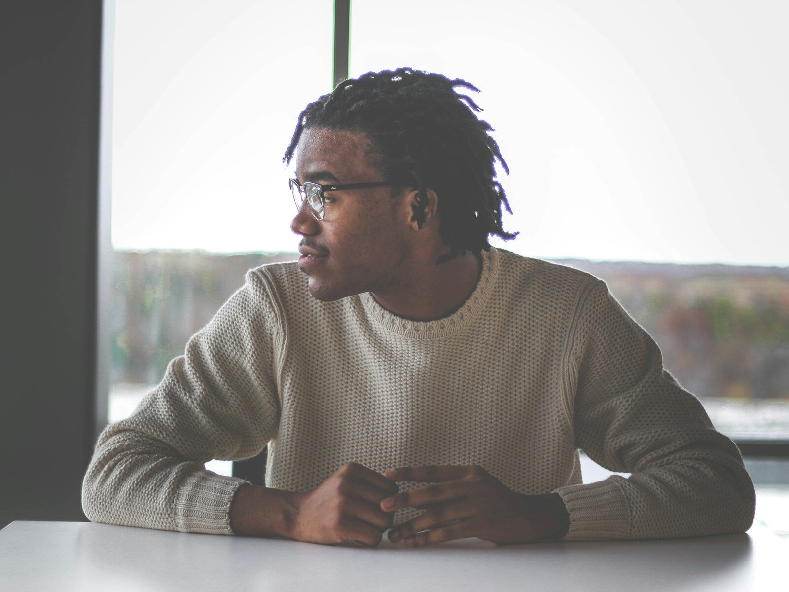 man with medication assisted treatment in white sweater around table