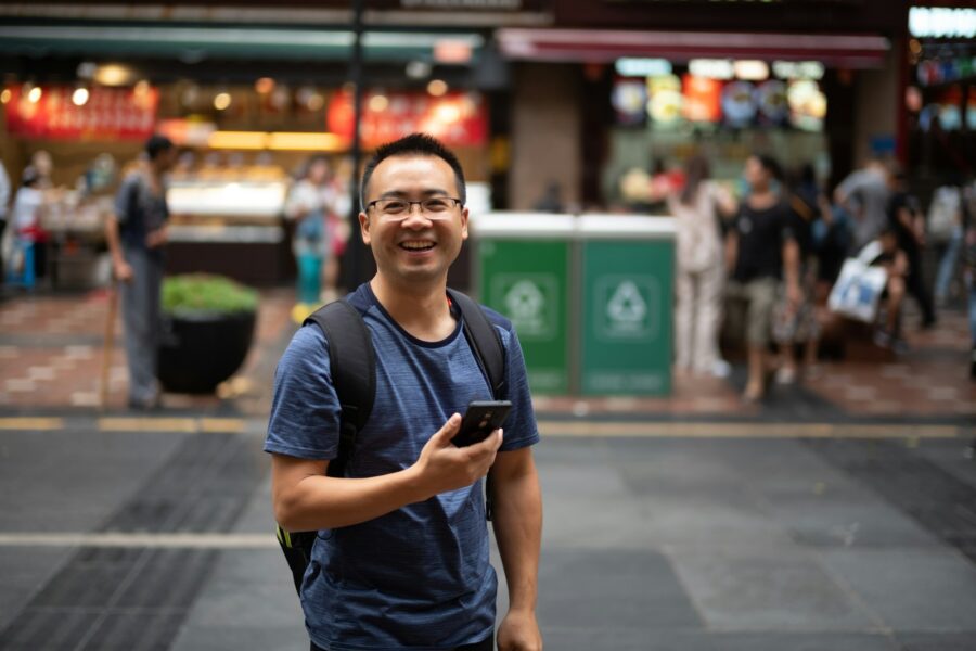Smiling man looking up the benefits of outpatient therapy on his phone
