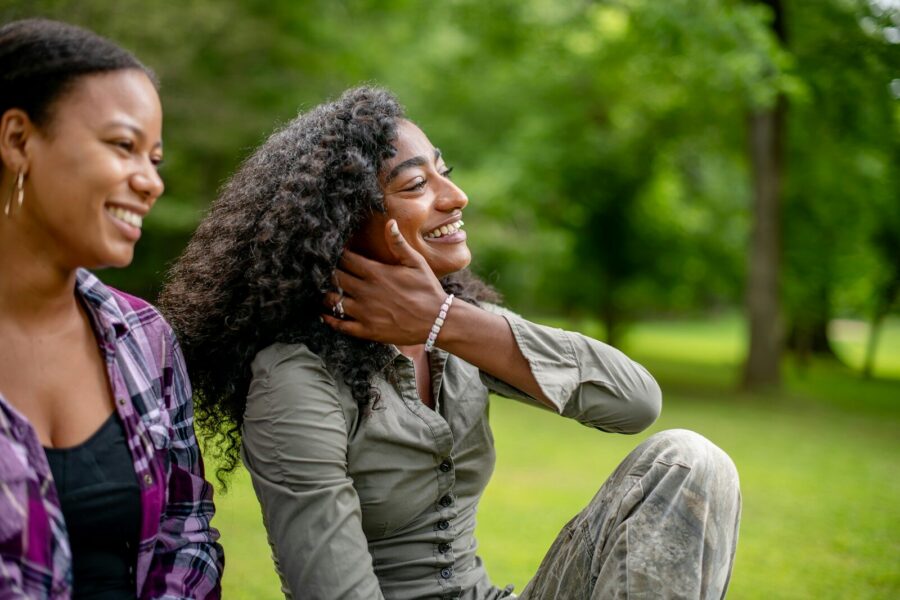Two smiling women in a park demonstrating emotional intimacy in recovery